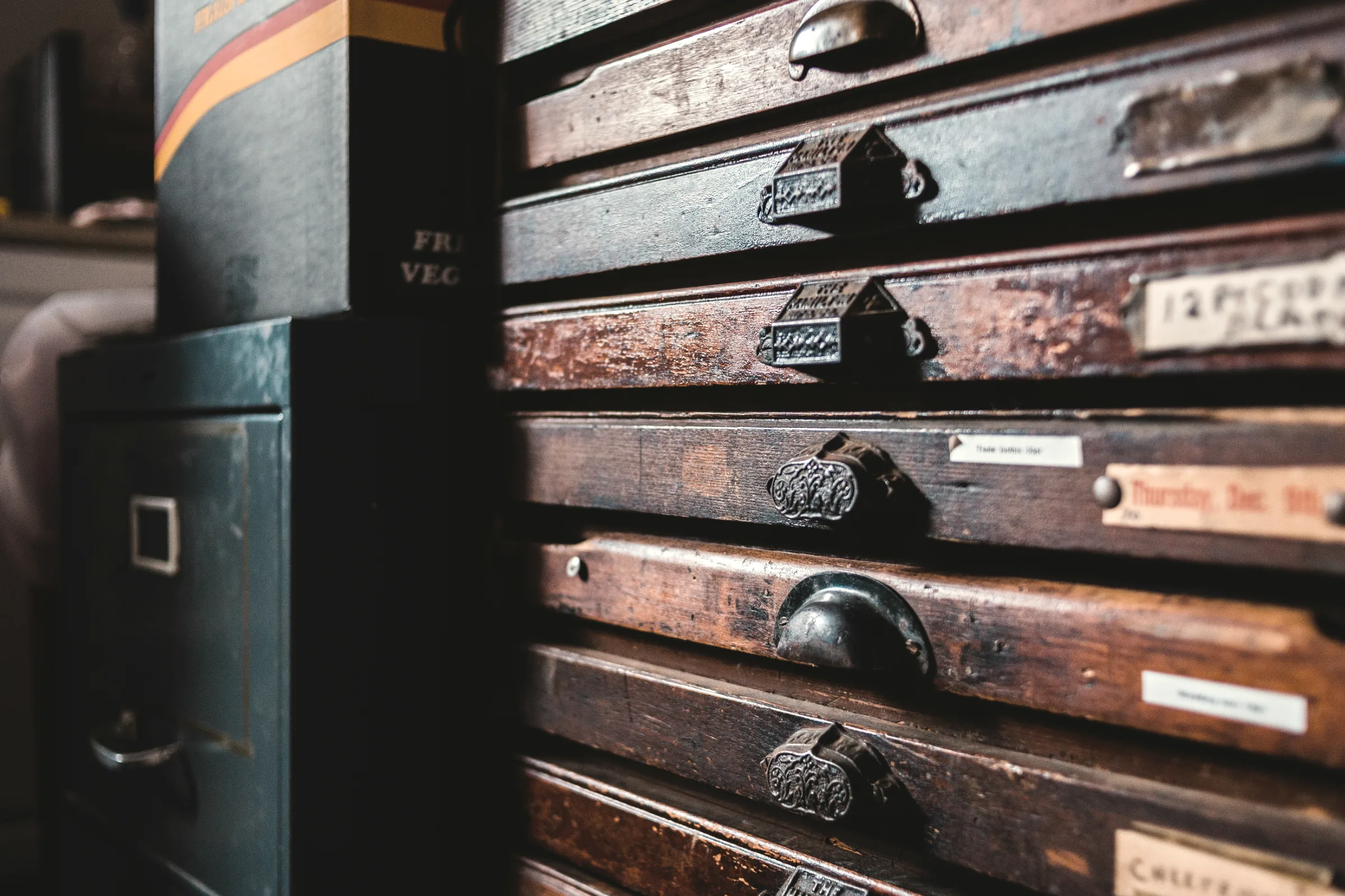 A wall of old wooden index drawers, each one labelled.