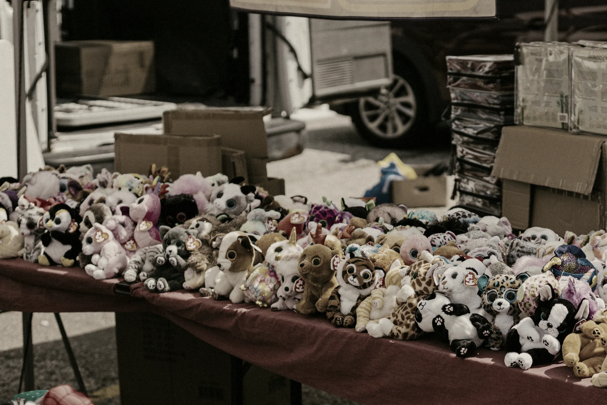 A market stall table covered with handmade goods for sale.